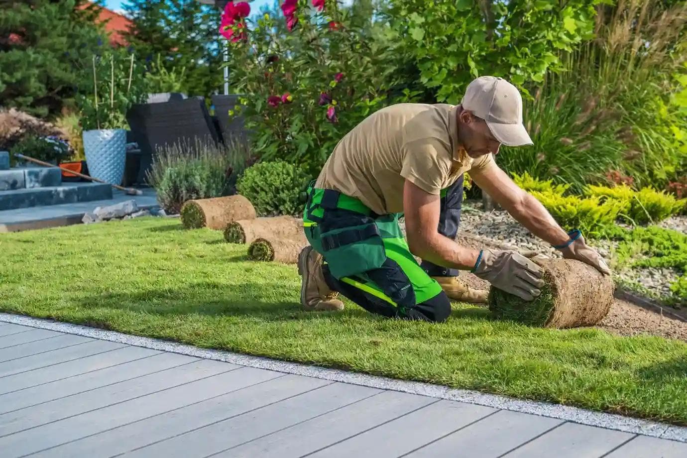 Landscaper unrolling fresh sod, installing a vibrant green lawn for a Central Oregon home's beautiful outdoor space.